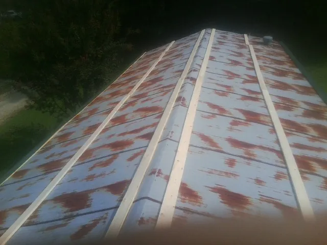 Rusted metal roof panels with new wood purlins before replacement — Storm Damage Roof Repair in Carter Lake by Roofing Brothers