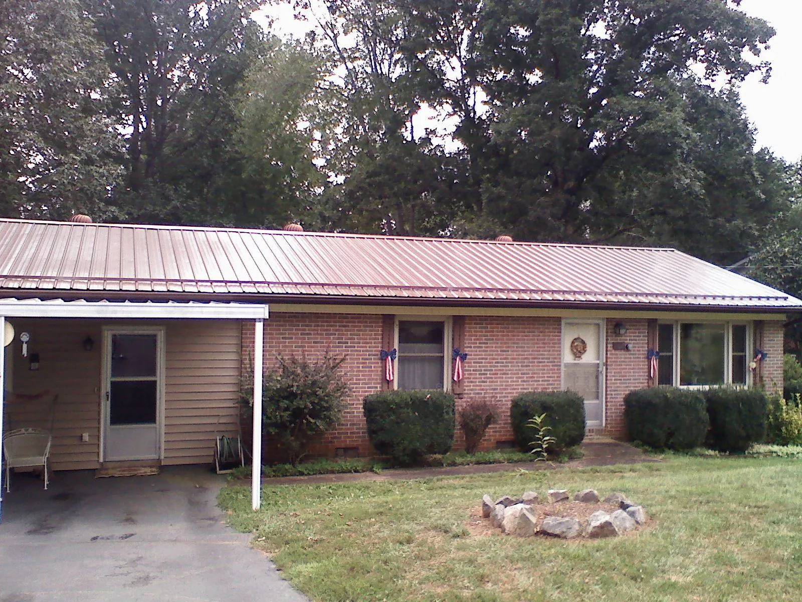 Bronze metal roof and carport on a brick ranch home — Roof Repair work by our crew in Carter Lake