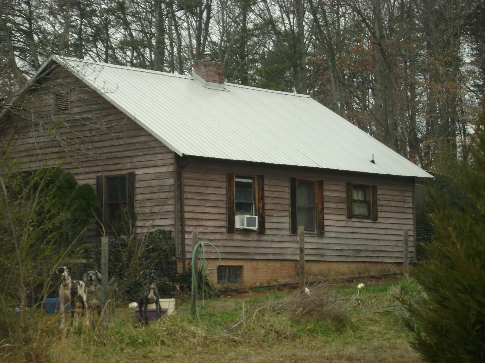 White metal roof on an old wood sided farmhouse, from a Metal Roof Installation job in Carter Lake